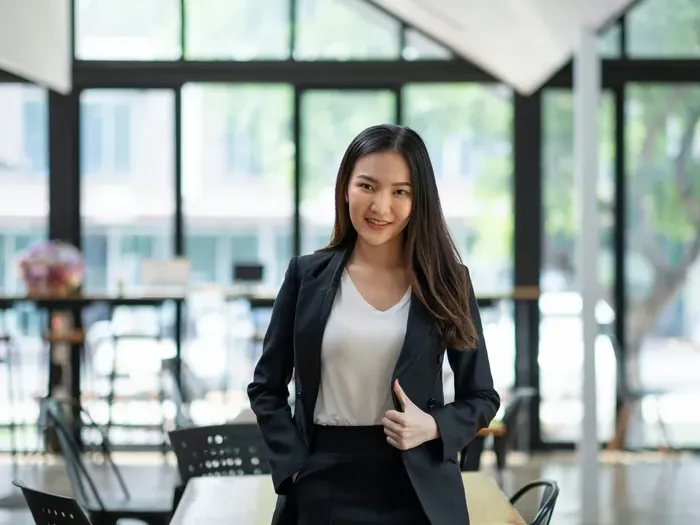 Confident professional woman in a modern workspace, showing CityBiz Guide Now helping users find local experts